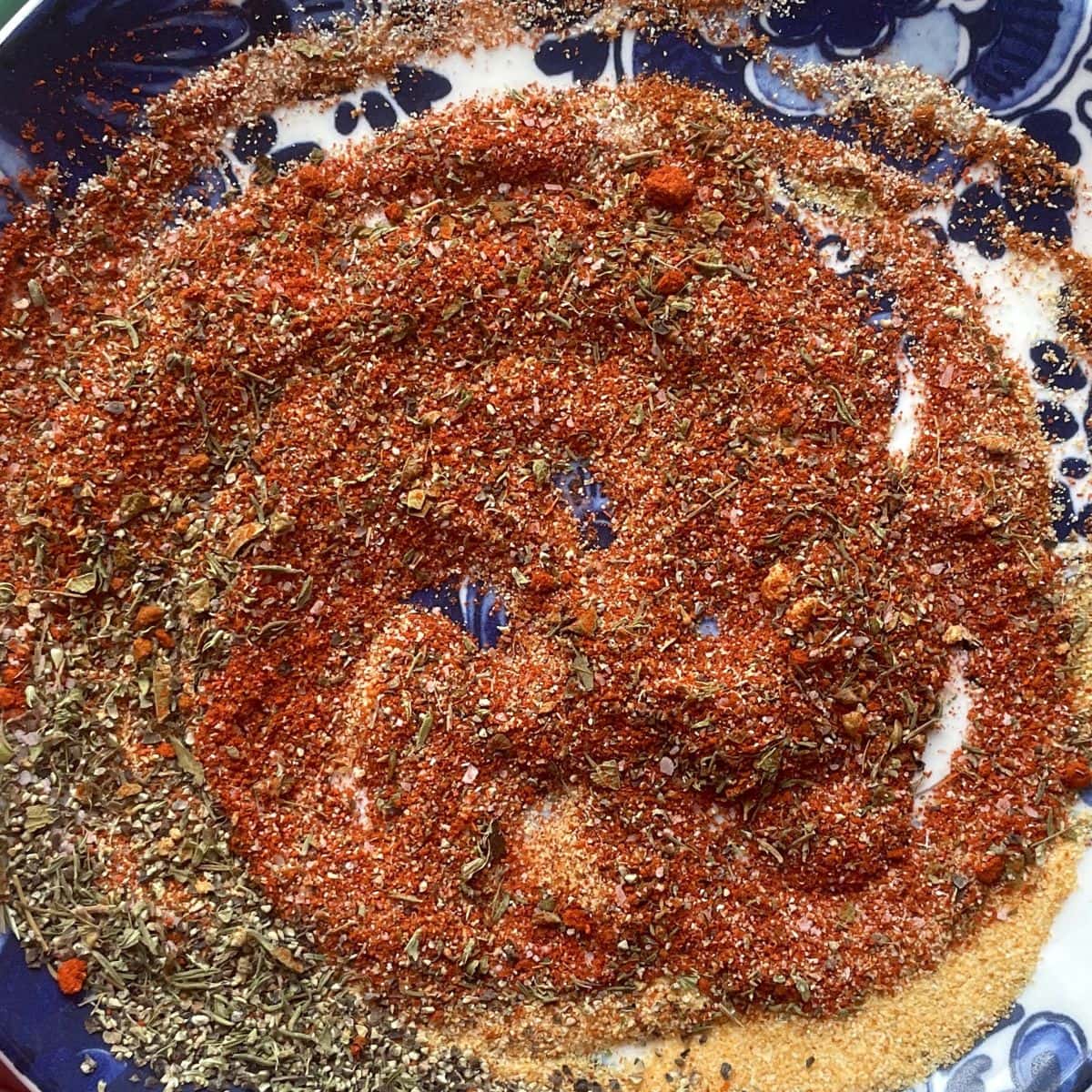 Homemade Cajun blackening seasoning mix swirled on a blue plate.