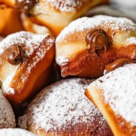Delicious Chocolate-Filled Donuts::A close-up of chocolate-filled donuts dusted with powdered sugar, showcasing their fluffy texture and sweet filling.
