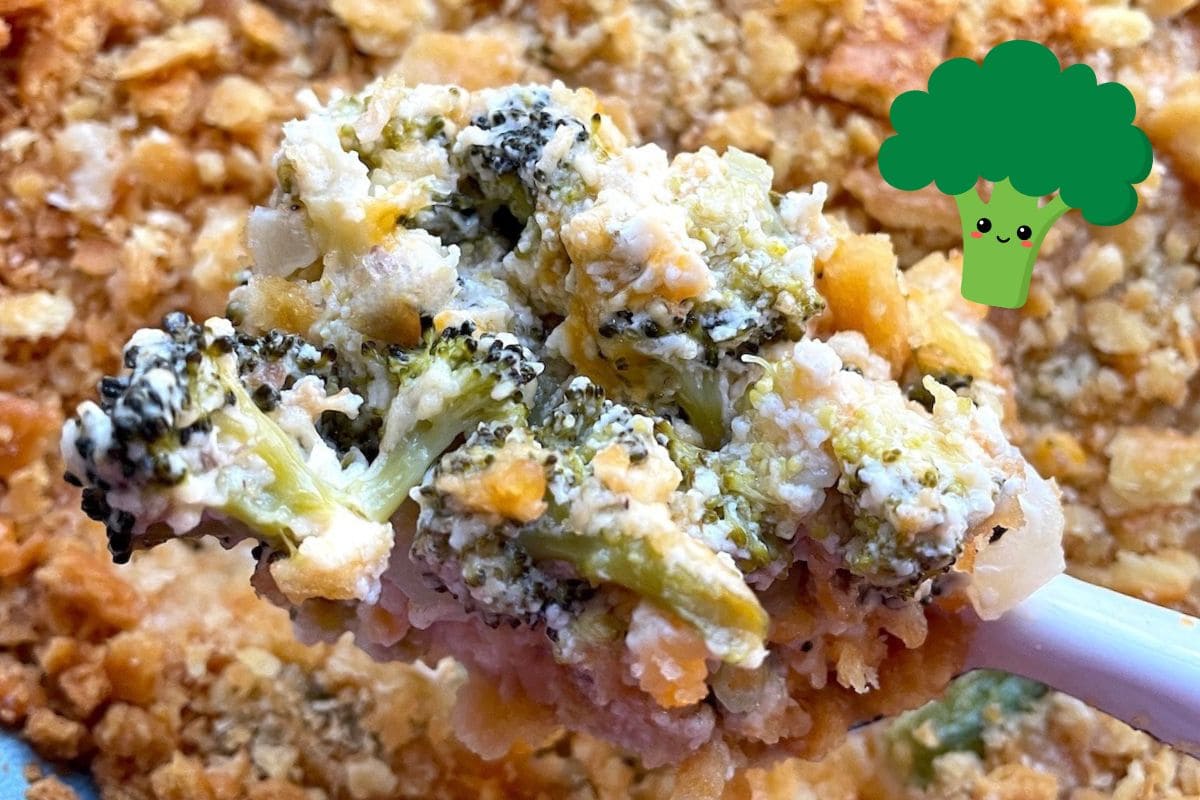 A close-up of a creamy broccoli casserole being served, showcasing tender broccoli florets and a crunchy topping, with a playful broccoli illustration in the corner.