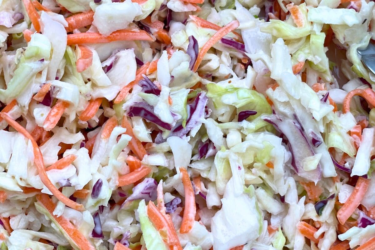 A vibrant close-up of a colorful coleslaw mixture featuring finely shredded cabbage and carrots.