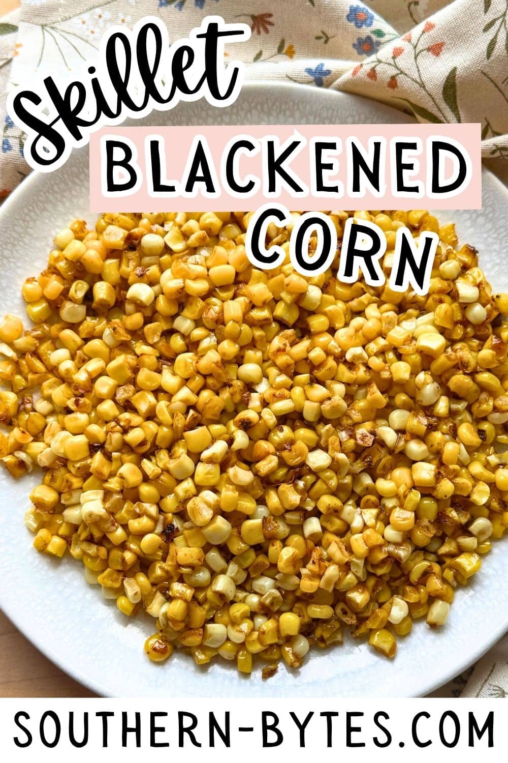 A close-up view of skillet blackened corn served on a white plate, showcasing its golden, caramelized texture.