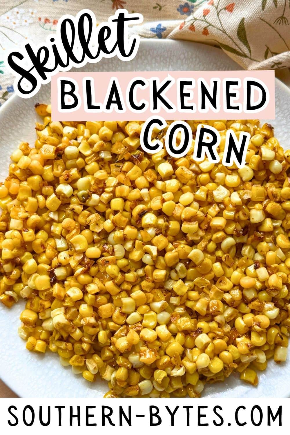 A close-up view of golden brown skillet blackened corn served on a white plate, showcasing its rich color and texture.
