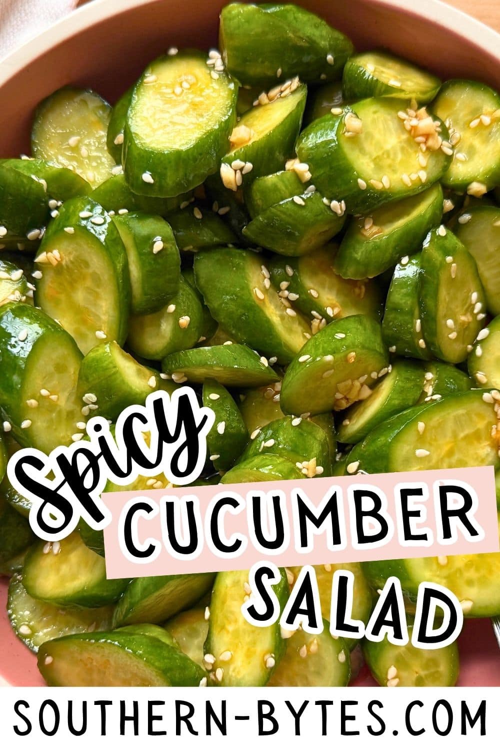 A close-up image of sliced cucumbers in a bowl, garnished with sesame seeds, showcasing a vibrant and fresh spicy cucumber salad.