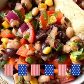 A vibrant bowl of black-eyed pea salad featuring red and yellow peppers, corn, onions, and cilantro, accompanied by crispy tortilla chips.